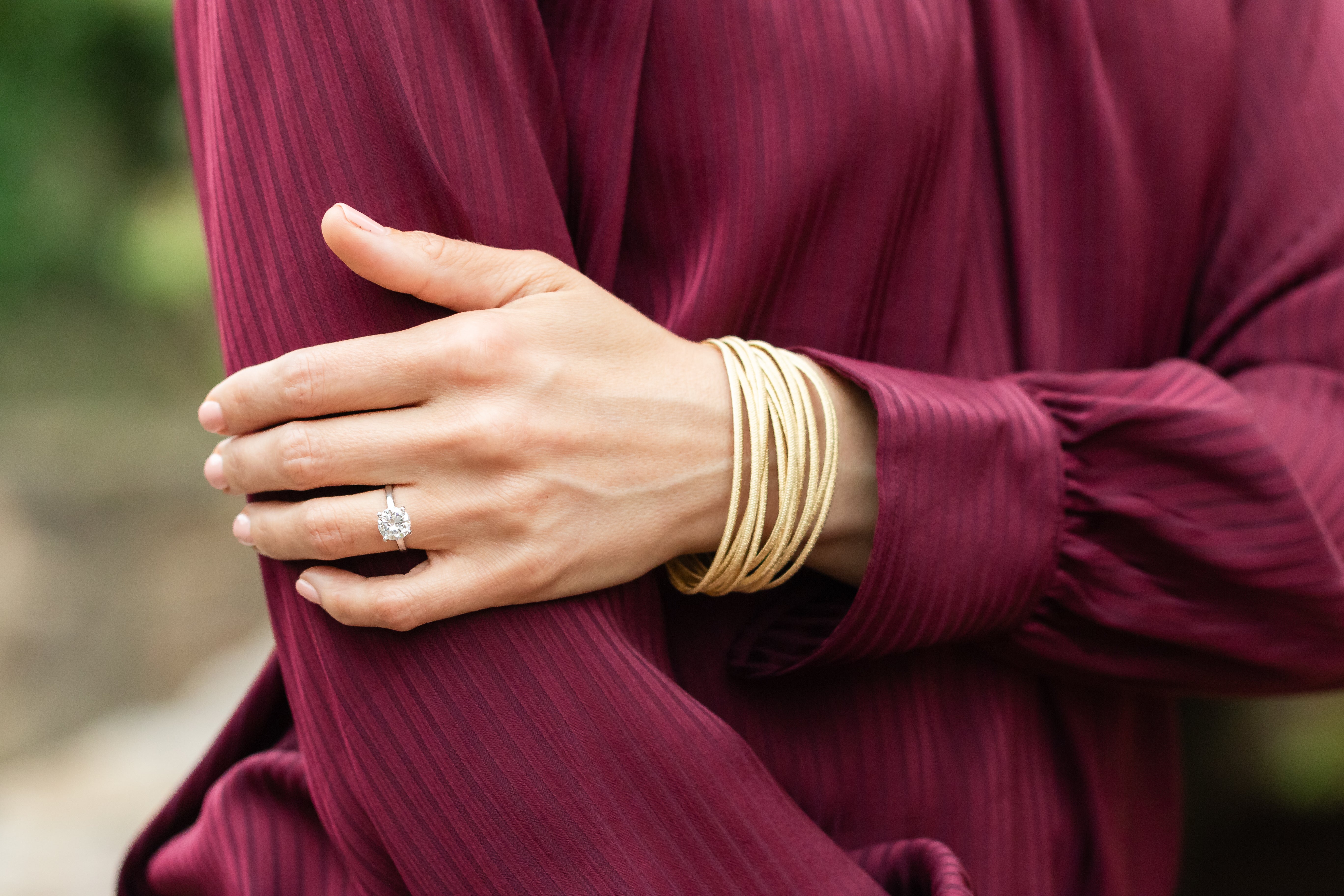 Close-up of a woman’s hand wearing an elegant oval engagement ring, showcasing its glow and timeless design.