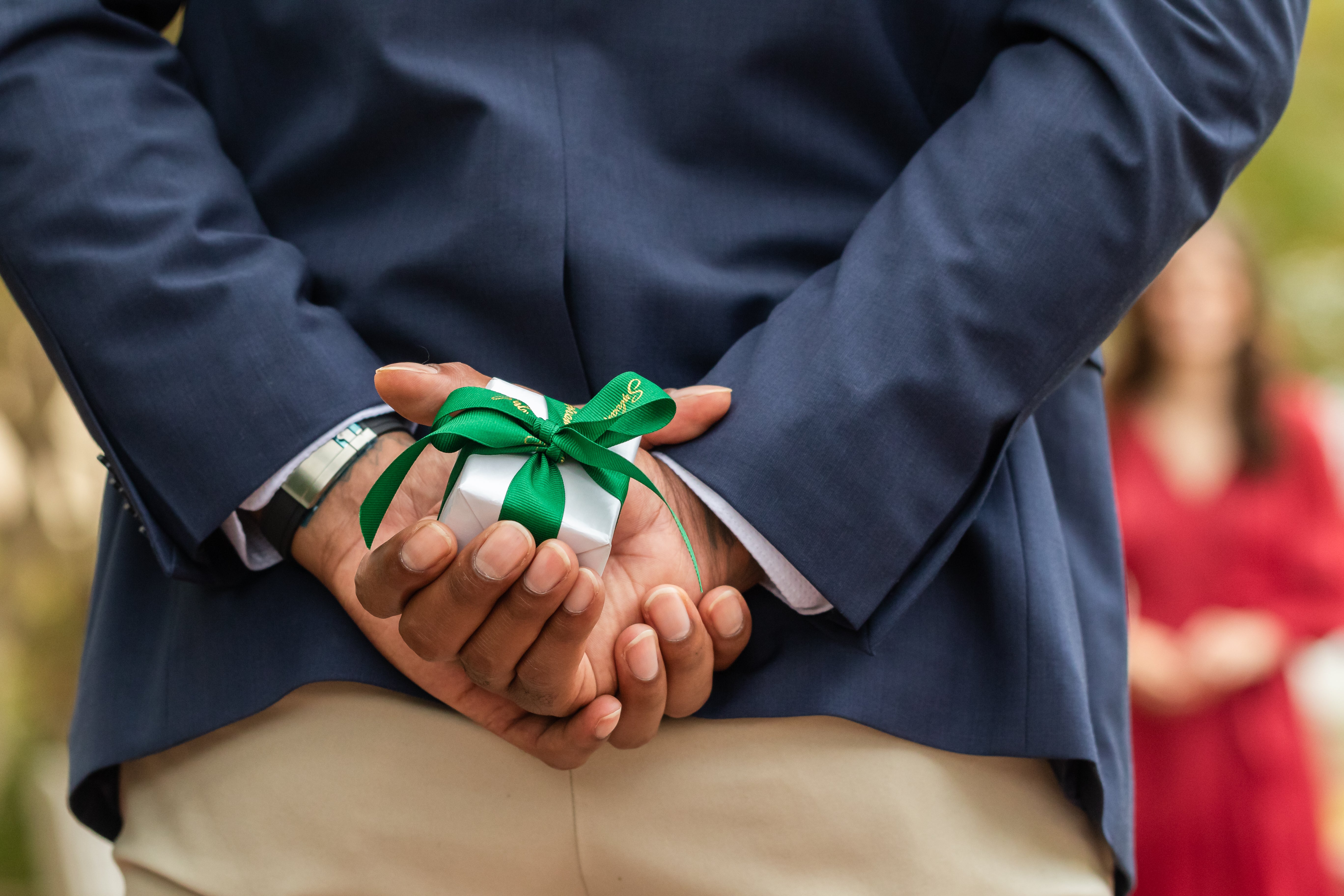 Man proposing to his partner with a ring box hidden behind his back, preparing to surprise with an engagement ring