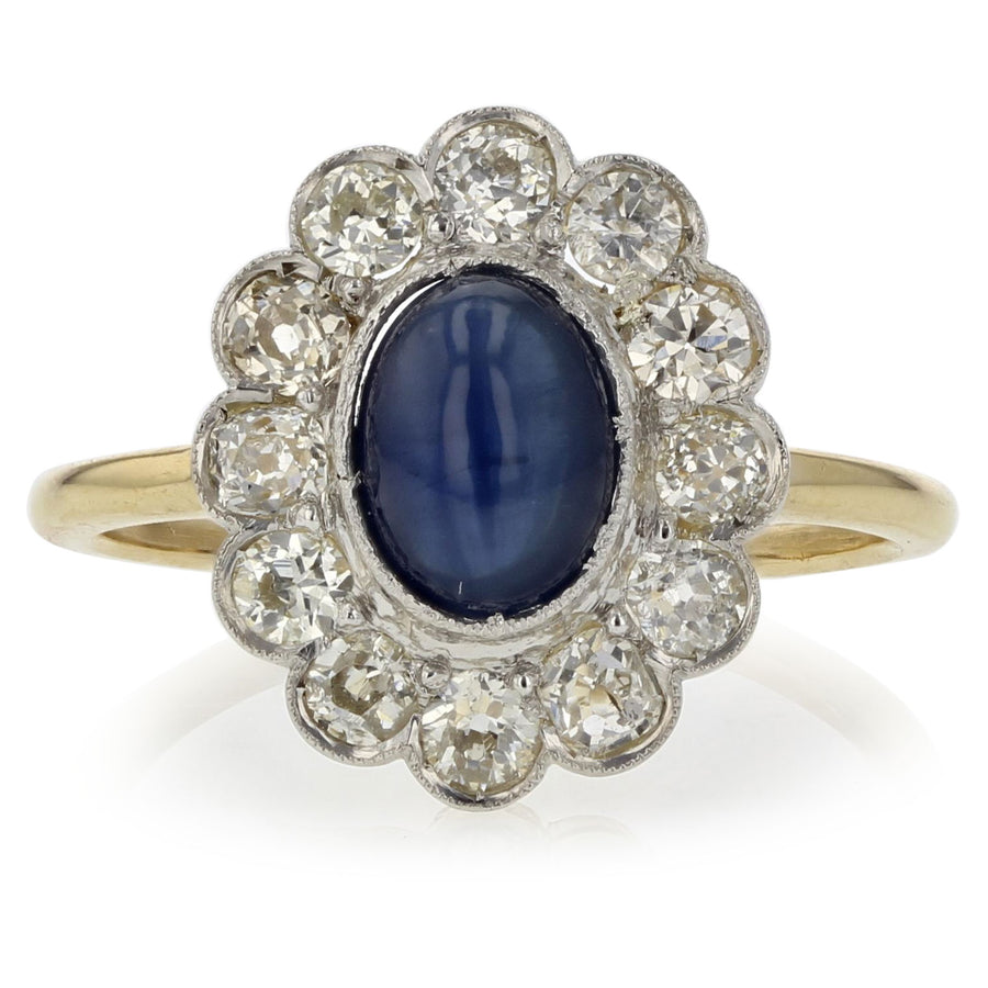 18KY/PLAT OV CAB BL SAPH=2.11CT AND 12 MIXED OLD CUT DIAS=1.20CT SET IN SCALLOPED BORDER UNDER BEZEL